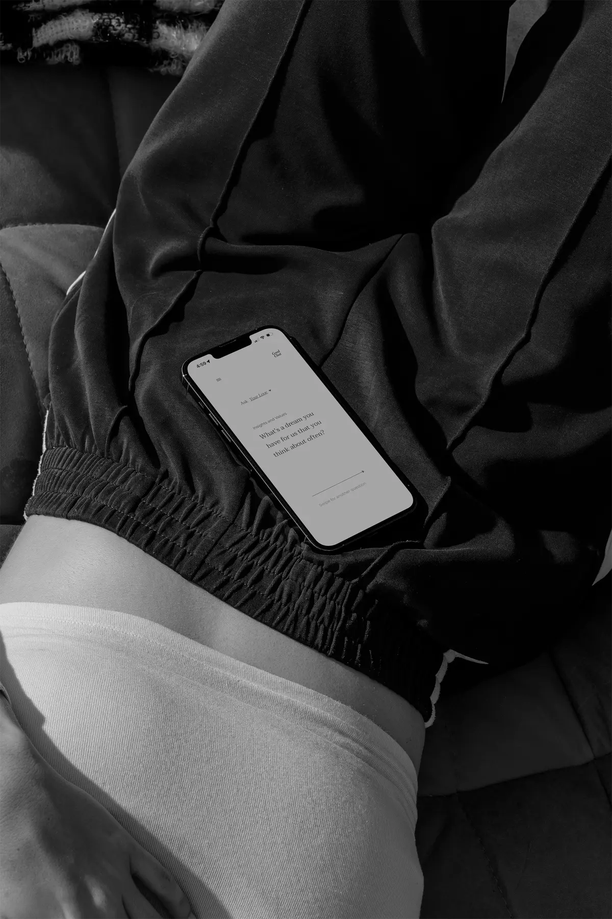 Ruby relaxing on a couch holding a phone with the Good Chat app open